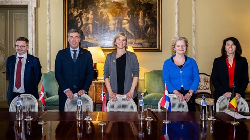 Representanter fra fem land som står ved et bord