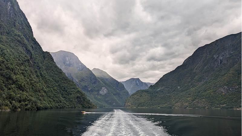 Norsk fjord med mørke skyer.