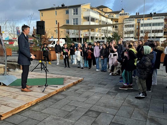 statsråden holder et innlegg foran en samling med skolebarn