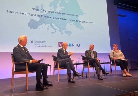 Four partisipants sitting on chairs on stage.