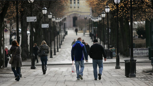 Bilde av hverdagsliv i Oslo, personer som går på fortauet i retning Stortinget