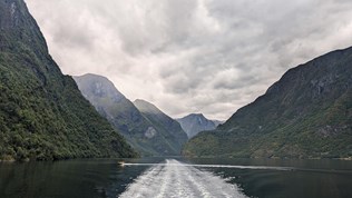 En fjord med fjell på hver side og overskyet vær