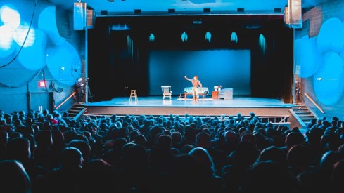 Publikum ser på teater med en person på scenen