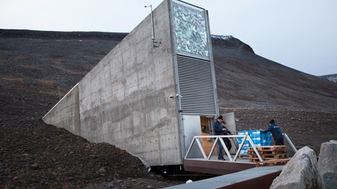 Fasaden på Frøkvelven på Svalbard med folk som deponerer frl.