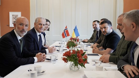 Møte mellom Ukraina og Norge i Stockholm. Møtedeltakerne sitter rundt et bord med hvit duk. Ukrainsk og norsk bordflagg. 