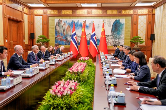 Meeting table. Norwegian delegation to the left, chines delegation to the right. Flags in the background.