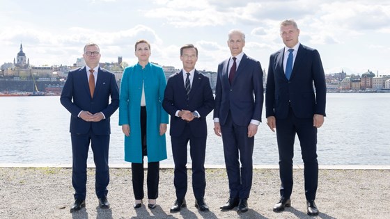 Gruppebilde av de fem nordiske statsministrene. Utendørs ved vann i sentrum av Stockholm.