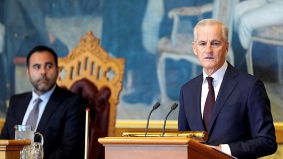 Statsminister Støre står bak talerstolen på Stortinget. Stortingspresidenten i bakgrunnen.