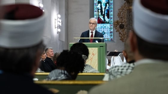 Statsministeren står bak en talerstol i domkirken. Kledd i dress.